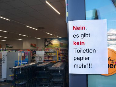 Sold out Toilet paper written on a notice stuck on a supermarket entrance door. Germany. clipart