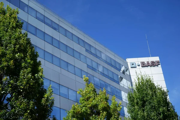Ön planda ağaçlar olan BASF ofis binasının bir parçası. Mavi gökyüzü. Levallois-Perret, Ile-de-France, Fransa.