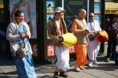 Saint-Michel Meydanı 'nda bir gazete büfesinin önünde şarkı söyleyen Krishna hayranları. Paris, Fransa.
