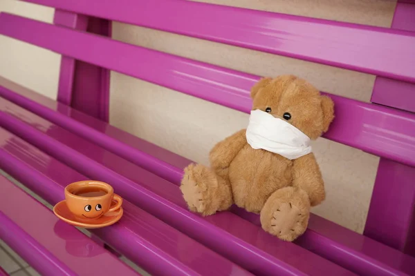 Urso Peluche Com Uma Máscara Cirúrgica Sentado Banco Violeta Uma — Fotografia de Stock