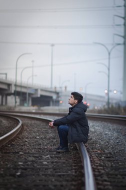 Demiryolundaki adam gökyüzünü izliyor.