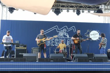 Tiflis Açık Hava 2019. Bir müzik festivalinde seyirciler ellerini kaldırdı ve sahnenin üstünden ışıklar süzülüyor. Yumuşak odak, yüksek ISO, taneli görüntü.