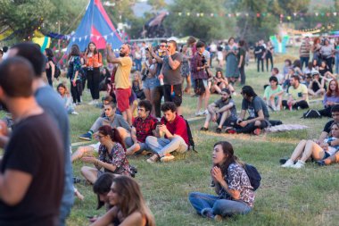 Tiflis Açık Hava 2019. Bir müzik festivalinde seyirciler ellerini kaldırdı ve sahnenin üstünden ışıklar süzülüyor. Yumuşak odak, yüksek ISO, taneli görüntü.
