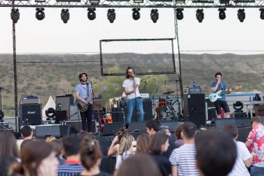 Tiflis Açık Hava 2019. Bir müzik festivalinde seyirciler ellerini kaldırdı ve sahnenin üstünden ışıklar süzülüyor. Yumuşak odak, yüksek ISO, taneli görüntü.