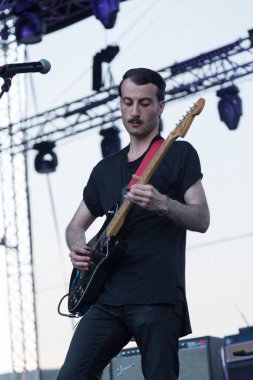 Tiflis Açık Hava 2019. Bir müzik festivalinde seyirciler ellerini kaldırdı ve sahnenin üstünden ışıklar süzülüyor. Yumuşak odak, yüksek ISO, taneli görüntü.