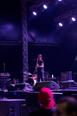 Tiflis Açık Hava 2019. Bir müzik festivalinde seyirciler ellerini kaldırdı ve sahnenin üstünden ışıklar süzülüyor. Yumuşak odak, yüksek ISO, taneli görüntü.