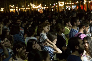 Tiflis Açık Hava 2019. Bir müzik festivalinde seyirciler ellerini kaldırdı ve sahnenin üstünden ışıklar süzülüyor. Yumuşak odak, yüksek ISO, taneli görüntü.