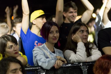 Tiflis Açık Hava 2019. Bir müzik festivalinde seyirciler ellerini kaldırdı ve sahnenin üstünden ışıklar süzülüyor. Yumuşak odak, yüksek ISO, taneli görüntü.