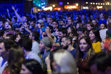 Tiflis Açık Hava 2019. Bir müzik festivalinde seyirciler ellerini kaldırdı ve sahnenin üstünden ışıklar süzülüyor. Yumuşak odak, yüksek ISO, taneli görüntü.