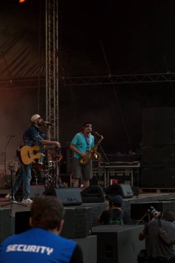 Tiflis Açık Hava 2019. Bir müzik festivalinde seyirciler ellerini kaldırdı ve sahnenin üstünden ışıklar süzülüyor. Yumuşak odak, yüksek ISO, taneli görüntü.