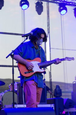 Tiflis Açık Hava 2019. Bir müzik festivalinde seyirciler ellerini kaldırdı ve sahnenin üstünden ışıklar süzülüyor. Yumuşak odak, yüksek ISO, taneli görüntü.