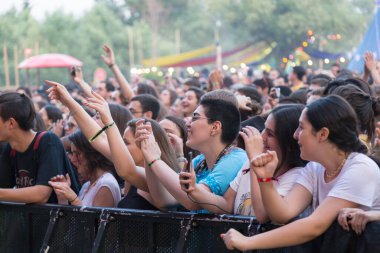 Tiflis Açık Hava 2019. Bir müzik festivalinde seyirciler ellerini kaldırdı ve sahnenin üstünden ışıklar süzülüyor. Yumuşak odak, yüksek ISO, taneli görüntü.