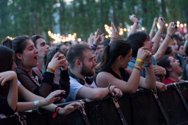 Seyirci bir Müzik Festivali ve sahne yukarıdan aşağı akış ışıklar kaldırdı elleriyle. Yumuşak odak, yüksek ISO, grenli görüntü.