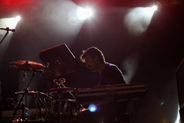 Seyirci bir Müzik Festivali ve sahne yukarıdan aşağı akış ışıklar kaldırdı elleriyle. Yumuşak odak, yüksek ISO, grenli görüntü.