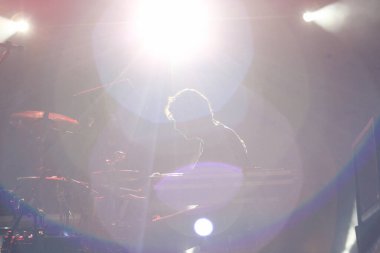 Seyirci bir Müzik Festivali ve sahne yukarıdan aşağı akış ışıklar kaldırdı elleriyle. Yumuşak odak, yüksek ISO, grenli görüntü.