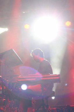 Seyirci bir Müzik Festivali ve sahne yukarıdan aşağı akış ışıklar kaldırdı elleriyle. Yumuşak odak, yüksek ISO, grenli görüntü.
