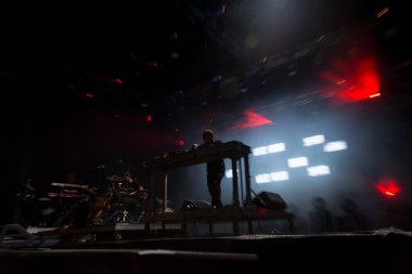 Seyirci bir Müzik Festivali ve sahne yukarıdan aşağı akış ışıklar kaldırdı elleriyle. Yumuşak odak, yüksek ISO, grenli görüntü.