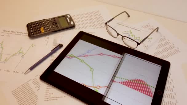 Biznesmen Pulpicie Wizualizuje Statystyki Nowymi Technologiami Tabletem Okularami Długopisami Kalkulatorem — Wideo stockowe