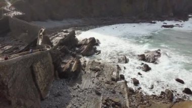 San Juan de Gaztelugatxe 'nin sahili, dalgalı denizler ve büyük uçurumlar manzaranın etrafını sarar..