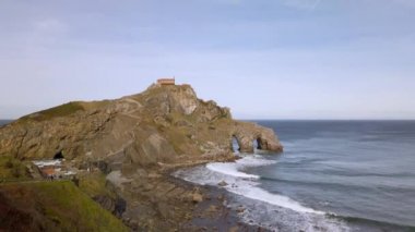 San Juan de Gaztelugatxe 'nin sahili, dalgalı denizler ve büyük uçurumlar manzaranın etrafını sarar..
