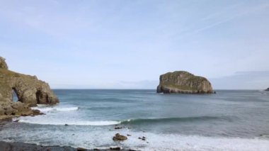 San Juan de Gaztelugatxe 'nin sahili, dalgalı denizler ve büyük uçurumlar manzaranın etrafını sarar..