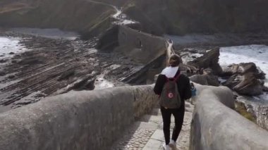 San Juan de Gaztelugatxe 'nin sahili, dalgalı denizler ve büyük uçurumlar manzaranın etrafını sarar..