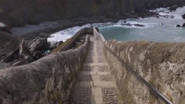 San Juan de Gaztelugatxe 'nin sahili, dalgalı denizler ve büyük uçurumlar manzaranın etrafını sarar..