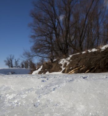 İlkbaharın başlarında harika bir manzara nehirde ve güneşli bir günde mavi gökyüzünde beyaz bulutlar