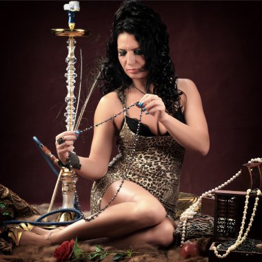 Stüdyoda Burgundy arka planında Doğulu kızların portresi nargile tüttürüp dans ediyor.