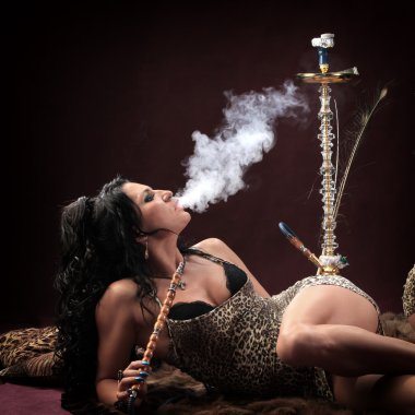 Stüdyoda Burgundy arka planında Doğulu kızların portresi nargile tüttürüp dans ediyor.