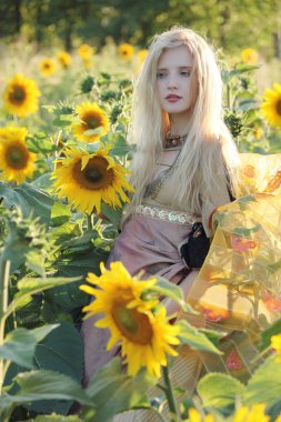 antika stili bir arka plan alanında ayçiçeği batımında güzel elbise uzun sarı saçlı güzel bir genç kız closeup portresi