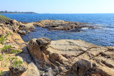 Güneşli bir günde Tayland açıklarında deniz manzaralı kayalık kıyı ve mavi su