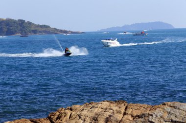 Güneşli bir günde Tayland açıklarında deniz manzaralı kayalık kıyı ve mavi su