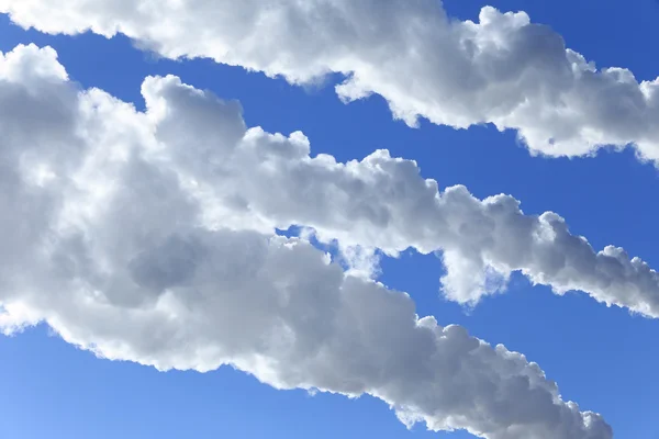 Fumaça branca contra o céu azul — Fotografia de Stock