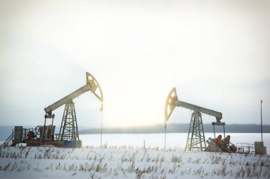 oil pumps in a snowy field clipart