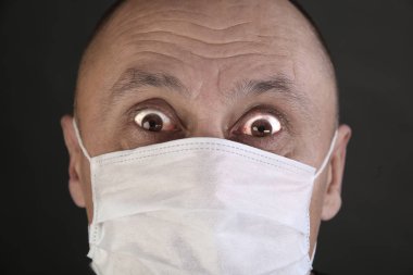 adam siyah T-shirt ve tıbbi maske