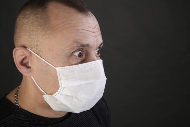 adam siyah T-shirt ve tıbbi maske