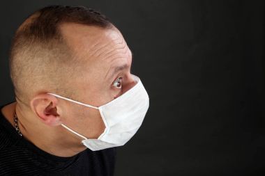 adam siyah T-shirt ve tıbbi maske