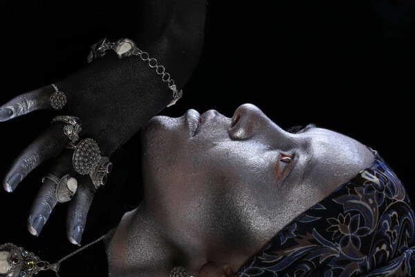 Macro silver jewelry in female hands model body art on black background