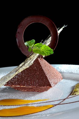 Çikolata ve reçelle süslenmiş beyaz bir tabakta nefis bir tatil tatlısı.