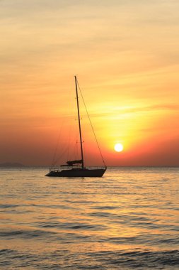 Deniz manzaralı gün batımı ve Tayland kıyılarında sönük yelkenli bir tekne.
