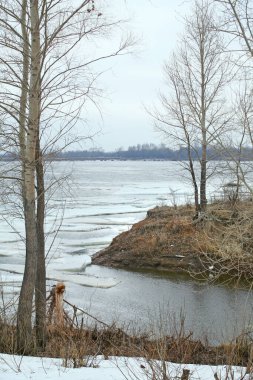 Baharın başlarında bulutlu bir günde nehir üzerindeki buz tabakası sürükleniyor.