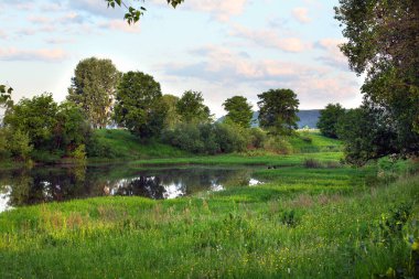 Yaz manzarası sabahın erken saatlerinde nehirde ve bulutlar suyun aynalı yüzeyine yansıdı.