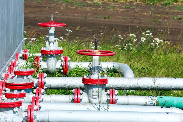 close-up of pipes and valves in a field on a background of grass in the summer
