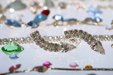 Makro zarif çeşitli mücevherler, kolyeler ve küpeler. Beyaz arka plan stüdyosunda renkli taşlar.