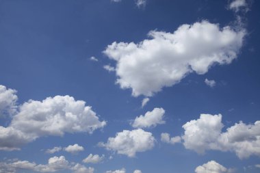 Güneşli bir yaz gününde parlak mavi gökyüzünde beyaz kabarık bulutların izole edilmiş görüntüsü.