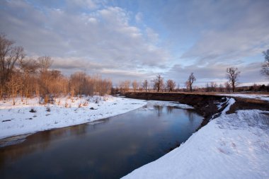 İlkbaharın başlarında gün batımında nehirde eriyen buz ve kardan oluşan bahar manzarası