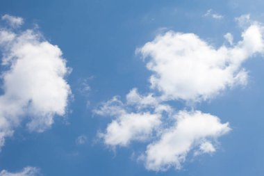 Baharda mavi gökyüzünde izole edilmiş beyaz bulutlar.