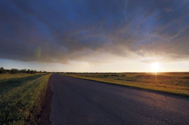 yaz manzara gündoğumu çayır ve dramatik bulutlar gökyüzü üzerinde yol üzerinde