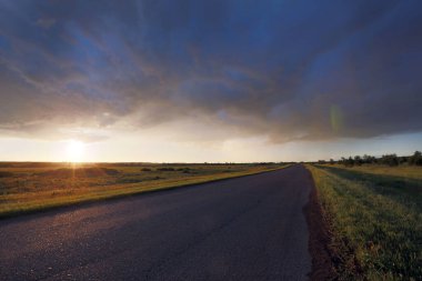 yaz manzara gündoğumu çayır ve dramatik bulutlar gökyüzü üzerinde yol üzerinde
